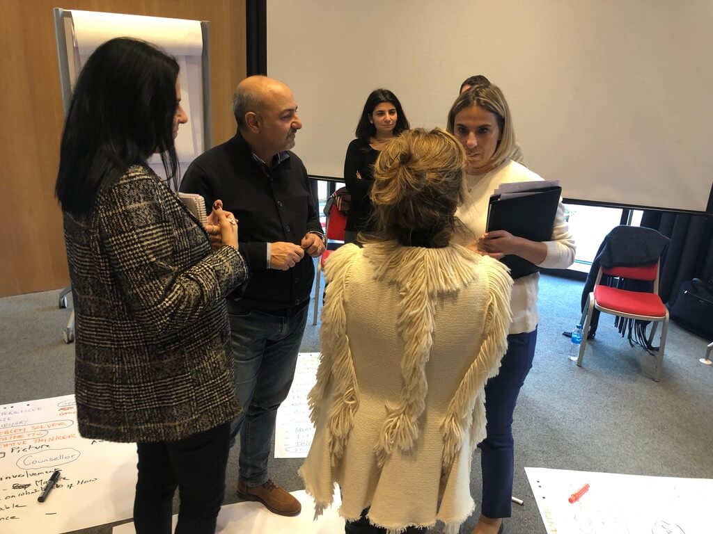 A small group of professionals engaging in reflective dialogue during a supervision session.