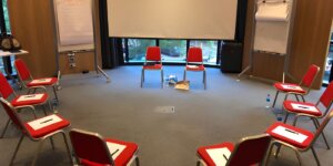 Empty workshop room with chairs arranged in a circle for a self-awareness training session. 