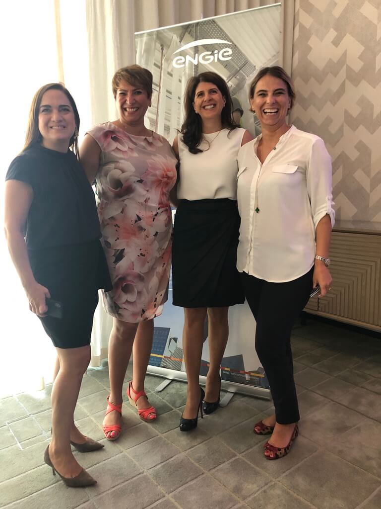 Four female leaders in professional attire at a business event focused on leadership and resilience.