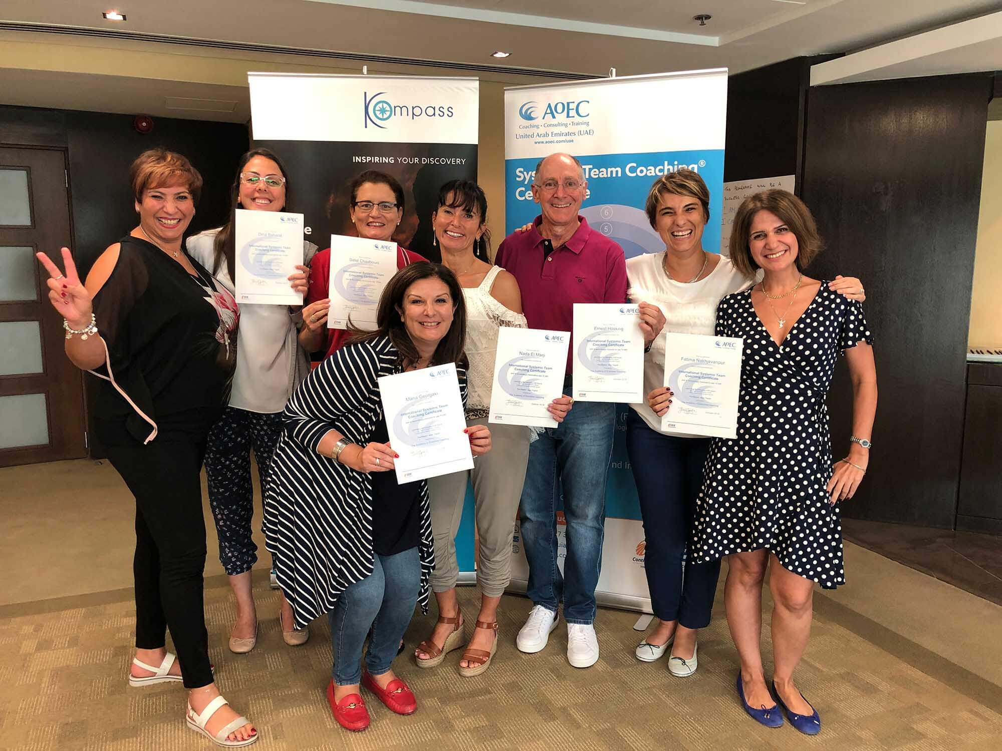 Graduates holding certificates after completing a programme to become an ICF coach.