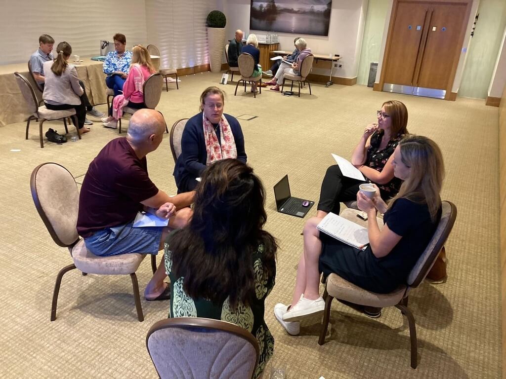 Small group discussions during a leadership session focused on key traits for thriving in a VUCA environment.
