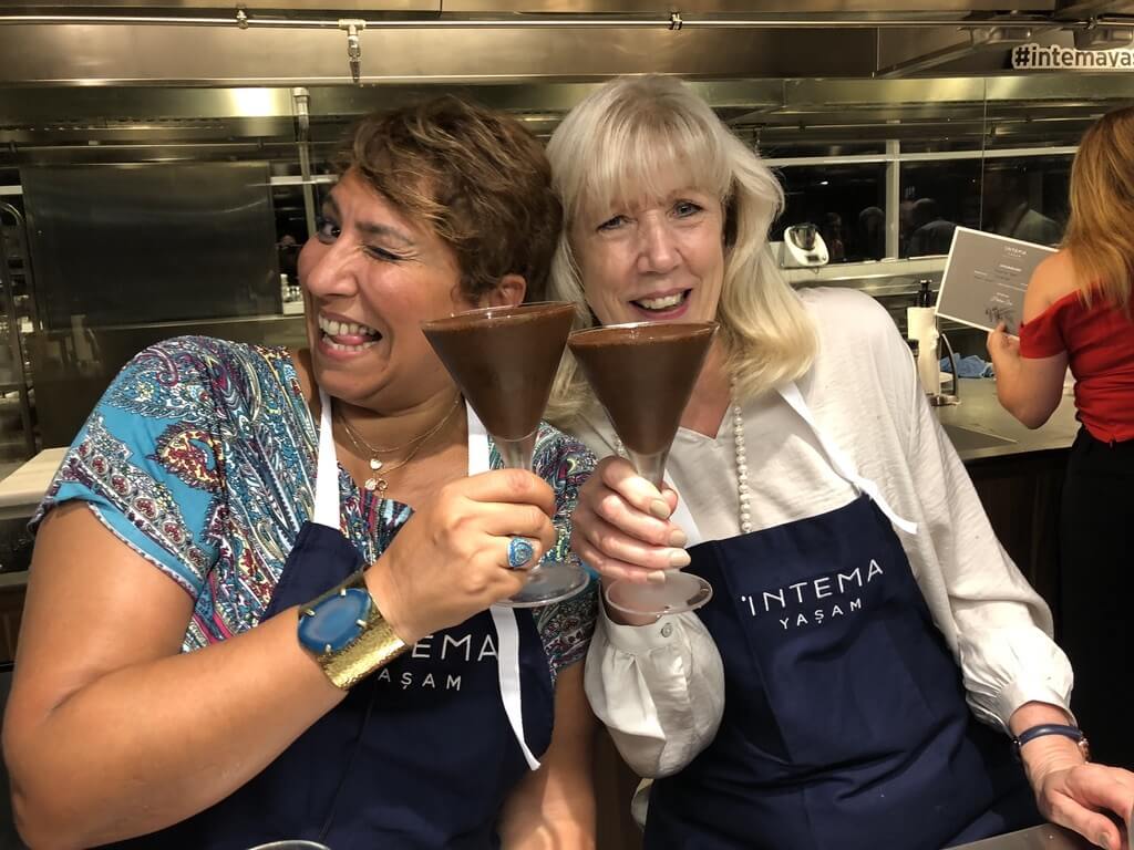 Two women smiling and toasting, celebrating progress and the joy of overcoming self-sabotaging habits.