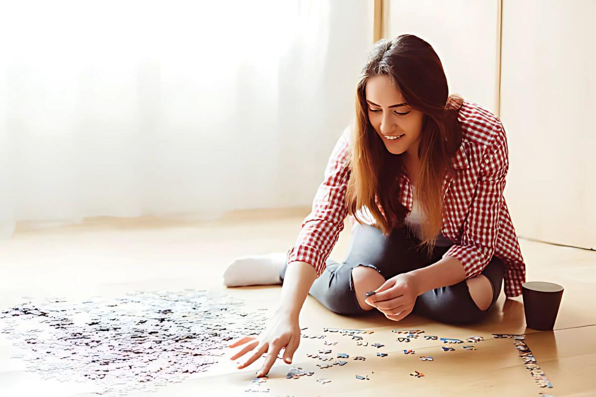 A person practising mental self-care by playing a jigsaw puzzle.