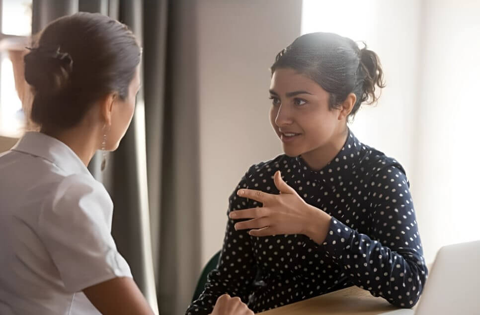 A professional woman coaching a client in a one-on-one session.