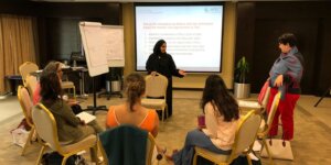 Facilitator guiding professionals through a conflict resolution workshop. 
