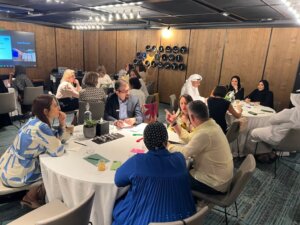 Attendees seated at tables collaborating during a coaching supervision workshop