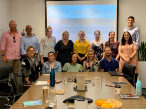 Participants standing around a table, posing for a group photo after a Continuing Professional Development session.