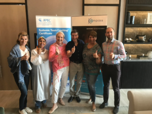 A group of coaches and attendees smiling and posing with thumbs up after a Continuing Professional Development session.