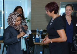Women networking in Abu Dhabi, with a coach guiding a team member on career growth strategies.