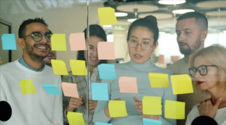 Team doing a team development activity on a board for strategy.