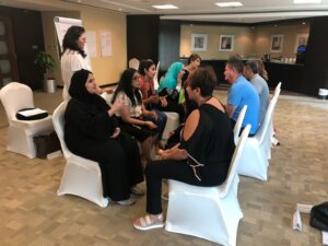 Attendees exchanging ideas in pairs during an executive coaching group activity