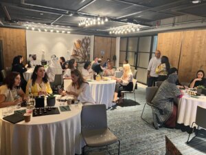 Attendees seated at tables collaborating during a leadership coaching workshop