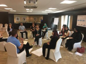Participants seated in a circle exchanging ideas during a leadership training session