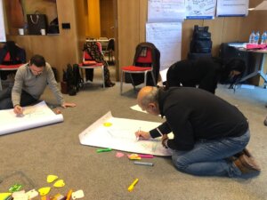 Participants preparing presentation materials during a leadership training workshop